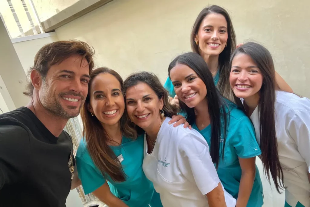 William Levy sonriendo junto al equipo médico de Odontomet Villena durante su consulta dental.